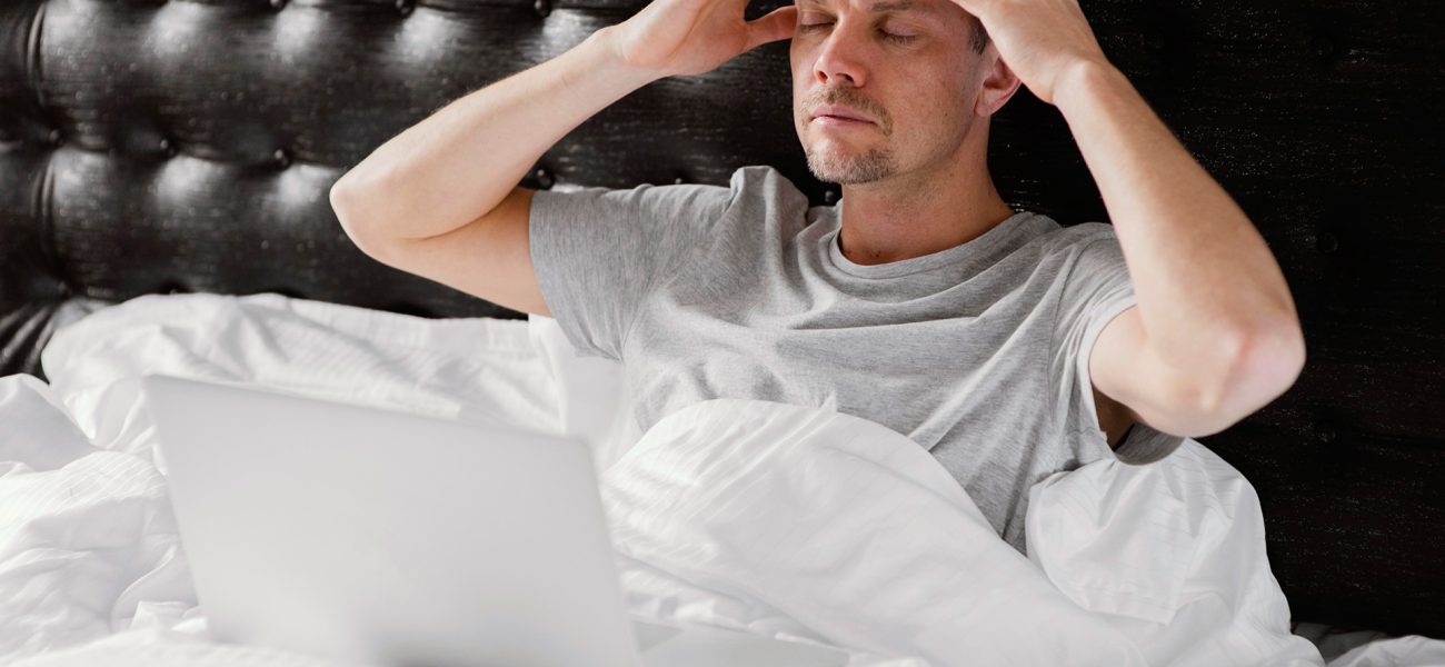 man-bed-using-laptop